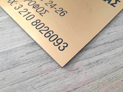Επιγραφή χάραξης με Laser ή Router σε χρυσό φύλλο Rowmark με μαύρα γράμματα